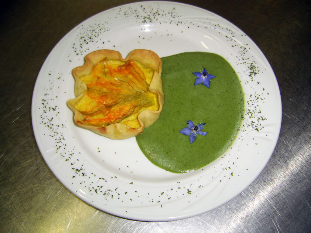 Tortino di fiori di zucchina su crema di borragine